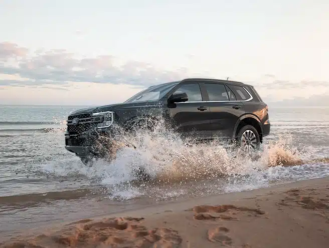Xe Ford Everest Platinum máy dầu 2.0L màu đen đang lội nước dọc bờ biển