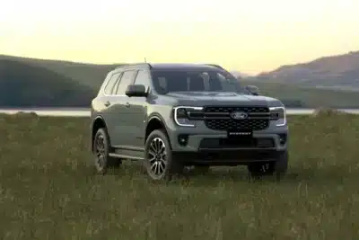 Xe Ford Everest Platinum máy dầu màu xanh thạch anh đỗ trên bãi cỏ cạnh bờ hồ