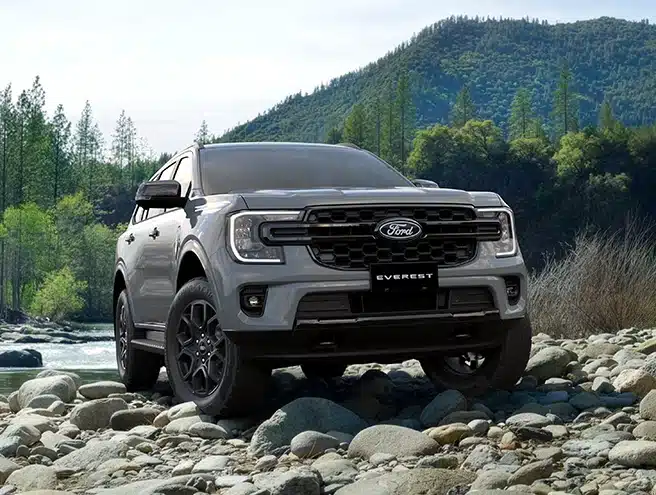 Xe Ford Everest Sport màu xám vận hành offroad trên bãi đá cuội ven suối núi