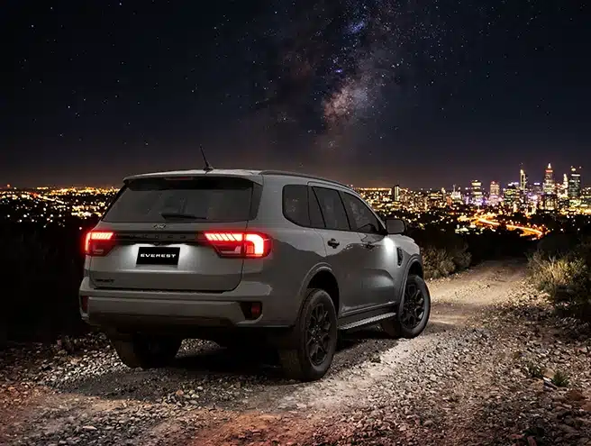 Đuôi xe Ford Everest Sport bật đèn hậu LED nổi bật trên đường sỏi dưới bầu trời sao đêm